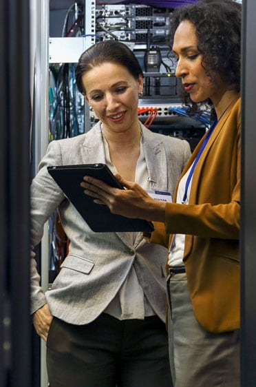 Two women looking at tablet in a server room