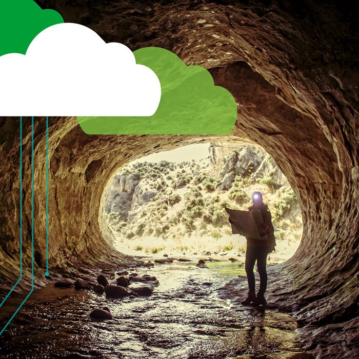 Person with map exploring cave with cloud overlay