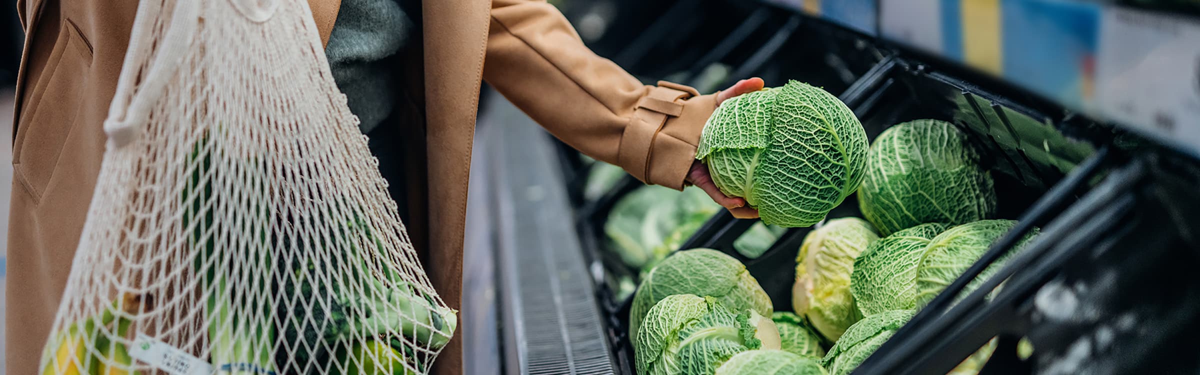 Woman picking veg in supermarket