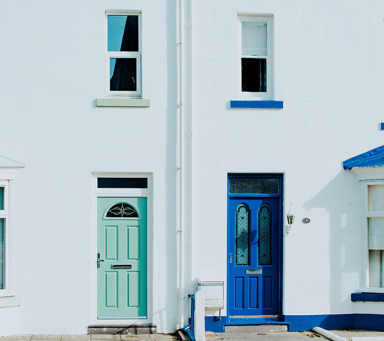 Outside of a white House with blue doors