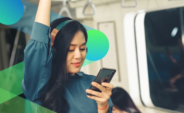 woman with headphones looking at mobile phone