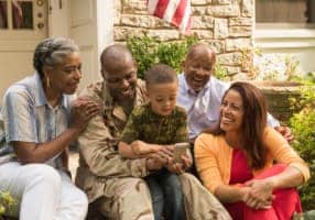 Veteran sitting with family on steps