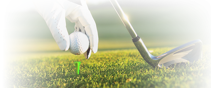 golfer setting up ball on tee